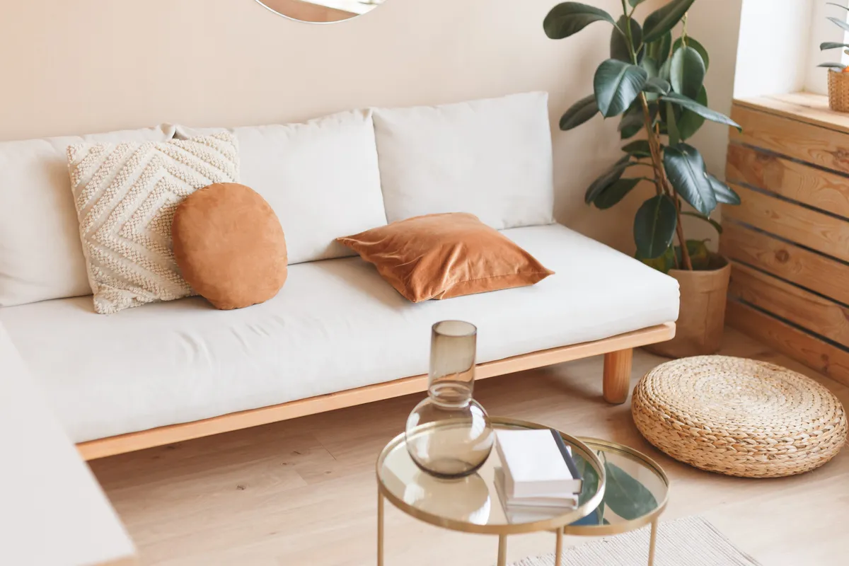 Light living room with beige sofa and glass table